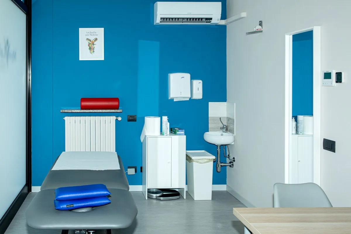 Cabina di trattamento con lettino e parete blu